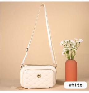 Détail du sac bandoulière blanc matelassé avec broderie cœur et fermetures dorées