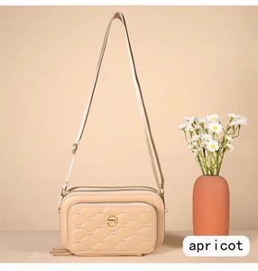Détail du sac bandoulière matelassé abricot avec coutures cœur et trois fermetures