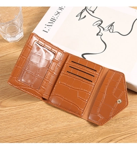 Detail of tan crocodile pattern wallet showing interior card slots and ID window