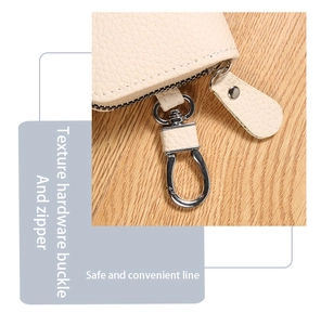 Close-up of beige lychee pattern PU leather key pouch with silver metal hook and zipper