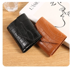 Detailed view of crocodile pattern faux leather wallets with envelope flap and logo