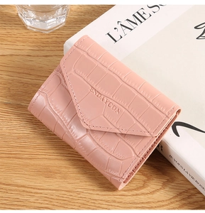Close-up of a pink crocodile pattern card holder on a wooden desk with elegant decor