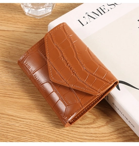 Close-up of brown crocodile texture on a mini envelope-style folding wallet