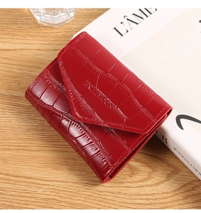 Detail of red crocodile texture on a trifold wallet with an embossed flap closure
