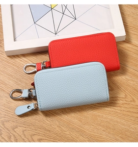 Detail of red and blue lychee grain PU leather key pouches with metal zippers and hooks