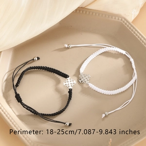 Detail of hand-woven cross bracelets in black and white with 18-25cm adjustable cord