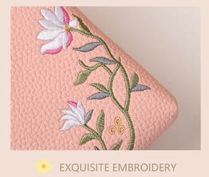 Macro detail of pink pebbled leather bag featuring exquisite floral embroidery craftsmanship