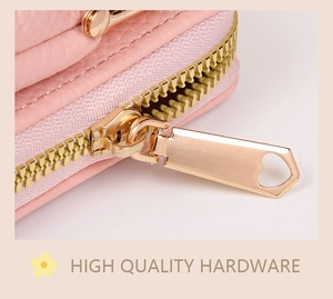 Detailed macro view of pink litchi leather bag featuring a gold heart-shaped zipper puller