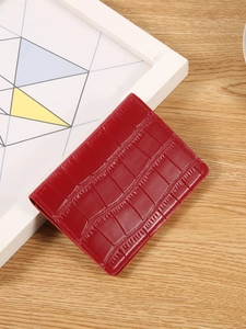 Red crocodile texture leather folding wallet with snap button on a wooden background