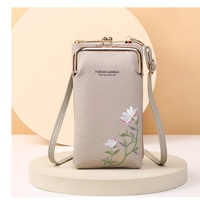 Detailed close-up of floral embroidery on lychee grain leather mobile phone bag