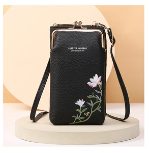 Close-up of black lychee grain leather phone bag featuring floral embroidery and metal clasp