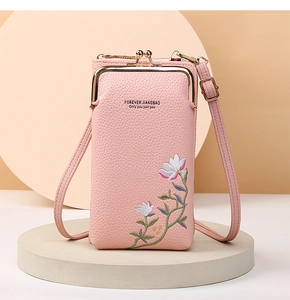 Detailed view of pink pebble grain phone bag with floral embroidery and gold metal clasp