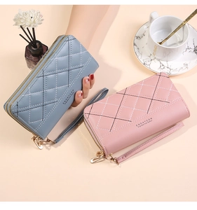 Detail view of quilted dual-zipper wallets in blue and pink with detachable wrist straps