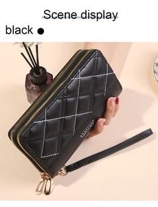 Detail view of black quilted long wallet for women with double zippers and wrist strap