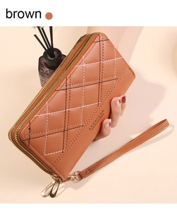 Brown quilted PU leather double zipper wristlet wallet held in hand with quilted pattern