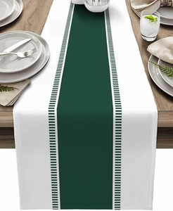 Detail of striped table runner featuring green and black patterns on a wooden table