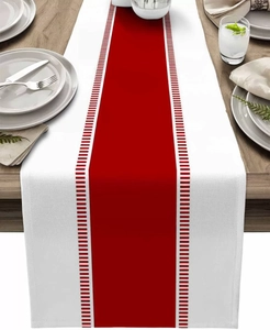 Close-up of modern red striped table runner on a wooden surface with dinnerware set
