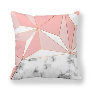 Detail of geometric peach skin cushion cover with marble patterns and gold trim