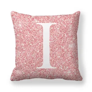 Détail de la housse de coussin rose pailletée avec lettre I blanche imprimée