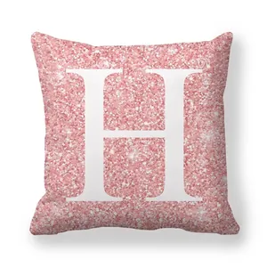 Détail d'une taie d'oreiller rose pailletée avec grande lettre H blanche décorative