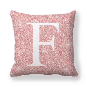 Vue détaillée d'une housse de coussin carrée à paillettes roses avec lettre F blanche et brillant