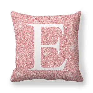 Détail de la texture rose pailletée sur housse de coussin avec la lettre E blanche