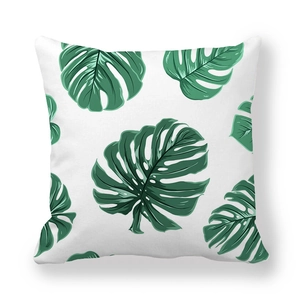 Detail of green monstera leaf print on white peach skin fabric cushion cover