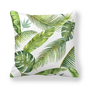 Macro view of green tropical monstera and palm leaf print on peach skin fabric