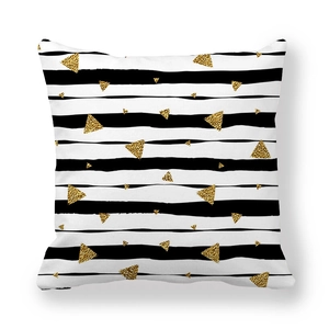 Détail de la housse de coussin carrée à rayures noires et blanches et motifs dorés