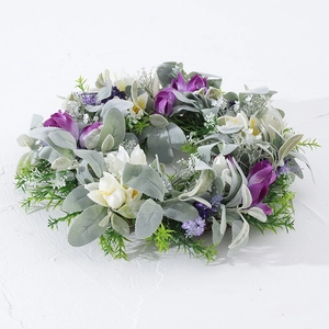 Macro detail of artificial lavender wreath with frosted green leaves on white stone surface