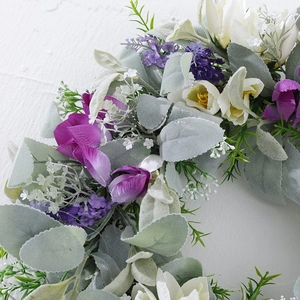 Detail of faux purple tulip wreath with soft gray-green leaves and silk flower texture