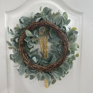 Détail du ruban de marguerites sur une couronne de feuilles vertes et rotin
