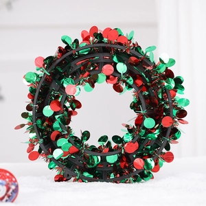 Macro detail of red and green metallic sequins on a Christmas wreath decoration