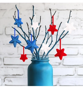 Close-up of red white and blue star ornaments with glitter and velvet texture detail