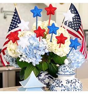 Close-up of glitter star picks in red white and blue inserted in floral decor
