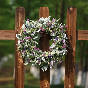 Artificial lavender and lamb's ear leaf wreath hanging on a rustic wooden fence