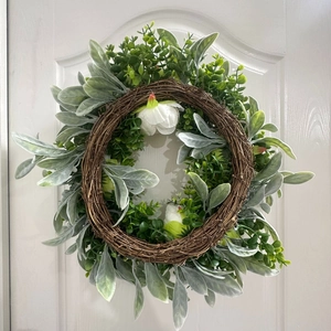 Detailed texture of lamb's ear leaves and white peony buds on a natural vine wreath base