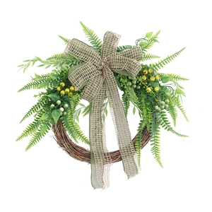 Artificial greenery wreath with berries and burlap bow on natural branch base for door decor