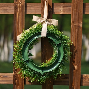 Artificial eucalyptus wreath with burlap bow shown from back view on wooden fence