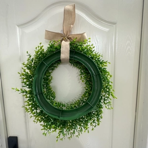 Rear view of eucalyptus wreath on white door showing sturdy frame and burlap bow detail