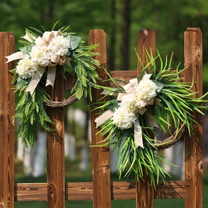 Farmhouse wreath with white hydrangeas and green leaves on a natural rattan base