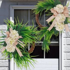 Close-up of farmhouse wreath with white hydrangea and rustic burlap bow on brick wall