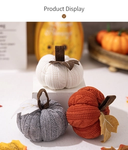 Close-up of three knitted pumpkins in white, grey, and orange for harvest decor
