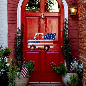 Detail of wooden patriotic American flag truck door hanger on a red house door