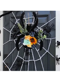 Dettaglio ghirlanda a ragno di Halloween con girasoli e fiori finti su una porta