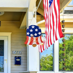 Detail of bell-shaped patriotic wooden sign with Let Freedom Ring text and flag design