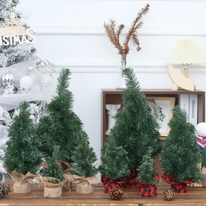 Miniature green Christmas trees with burlap and plaid bases for tabletop holiday decor