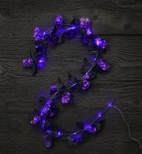 Détail de roses violettes artificielles et lumières LED sur guirlande d'Halloween