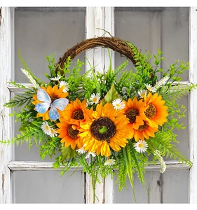 Detailaufnahme von Sonnenblumenkranz mit blauem Schmetterling auf rustikalem Holzgrund