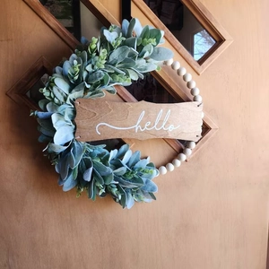 Detail of wooden Hello wreath with artificial lambs ear leaves on a rustic door